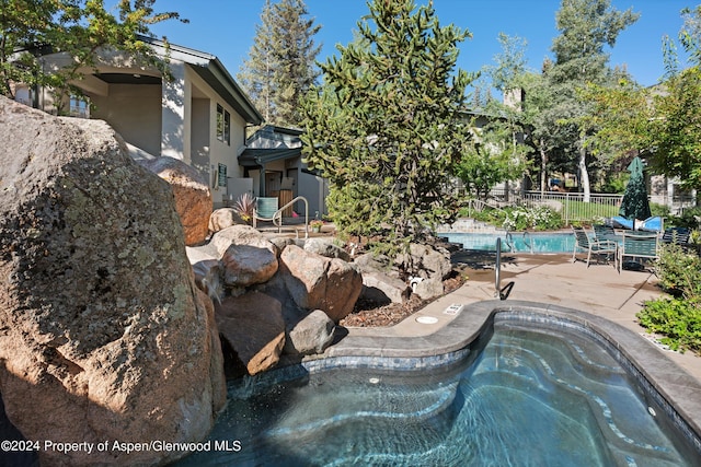 view of pool with central AC, a hot tub, and a patio area