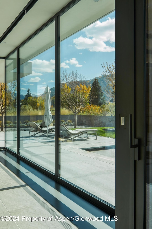 doorway to outside featuring a healthy amount of sunlight and floor to ceiling windows