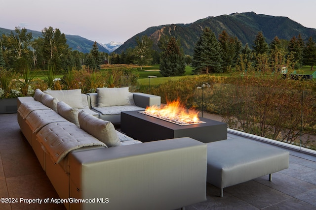 patio terrace at dusk with a mountain view and an outdoor living space with a fire pit