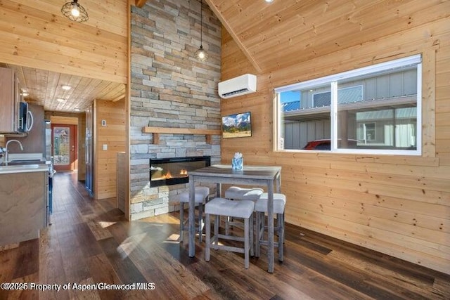 dining area featuring a fireplace, a wall unit AC, and wood walls