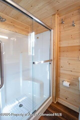 bathroom with walk in shower, wood-type flooring, wooden ceiling, and wood walls