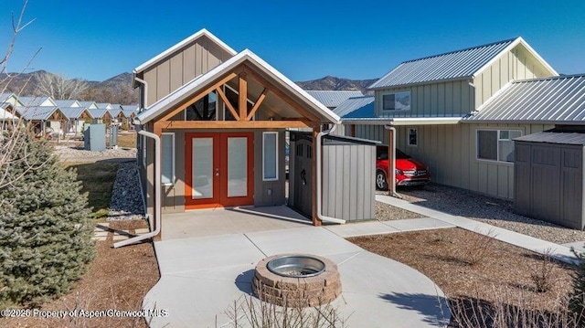 rear view of property featuring french doors, a mountain view, and an outdoor fire pit