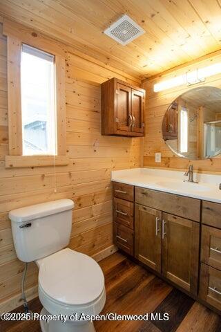 bathroom with wood-type flooring and wood walls