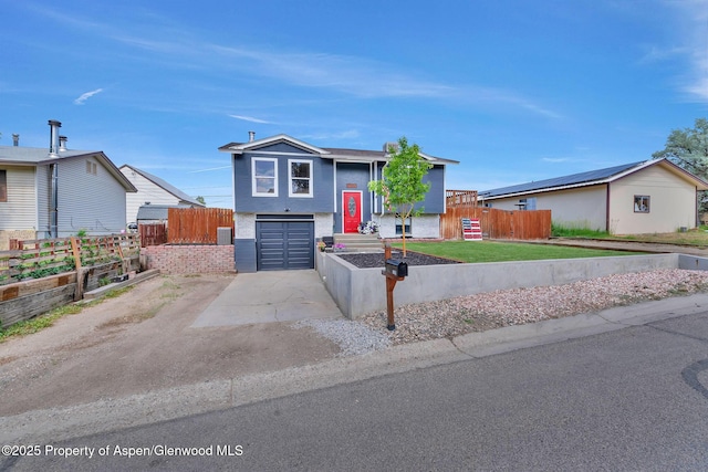 1186 Washington St, Craig, CO 81625 - bi-level home with concrete driveway, an attached garage, and stucco siding