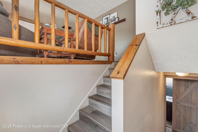 1186 Washington St, Craig, CO 81625 - stairs featuring wood finished floors and a textured ceiling