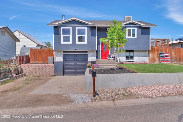 1186 Washington St, Craig, CO 81625 - split foyer home featuring an attached garage, driveway, brick siding, and stucco siding