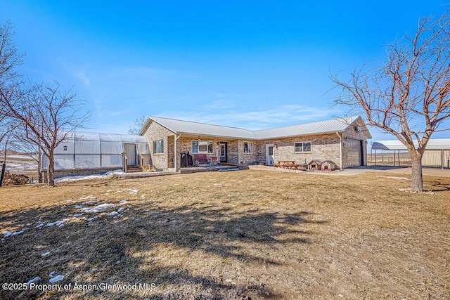 37 Pronghorn Rd, Craig, CO 81625 - rear view of house featuring a garage, a metal roof, brick siding, and covered porch