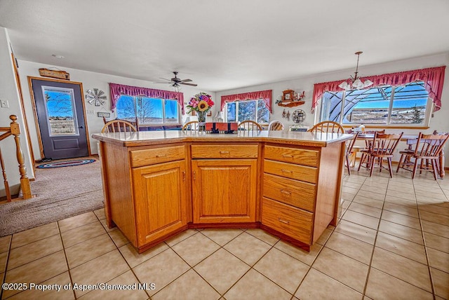 37 Pronghorn Rd, Craig, CO 81625 - kitchen featuring ceiling fan, light countertops, light tile patterned floors, brown cabinetry, and hanging light fixtures