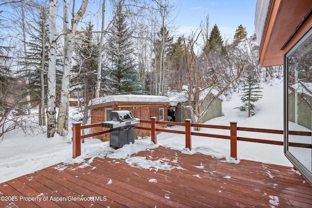 snow covered deck featuring a grill