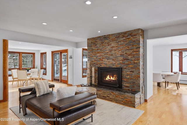 living room featuring light hardwood / wood-style flooring and a stone fireplace