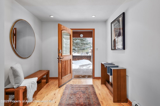 entryway with light wood-type flooring and a baseboard heating unit