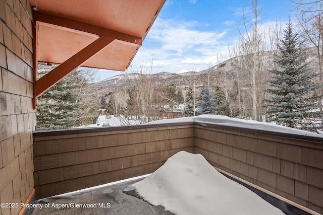 snow covered back of property with a mountain view