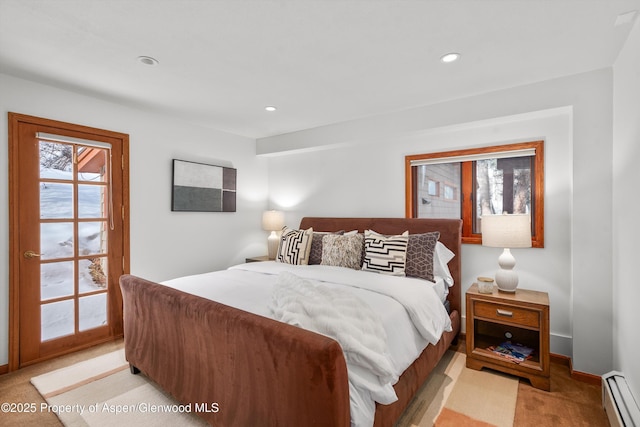 bedroom with a baseboard heating unit and light carpet