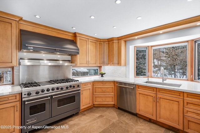 kitchen with light stone countertops, wall chimney range hood, sink, backsplash, and stainless steel appliances