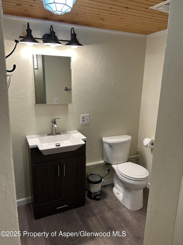 bathroom with hardwood / wood-style floors, vanity, toilet, and wood ceiling