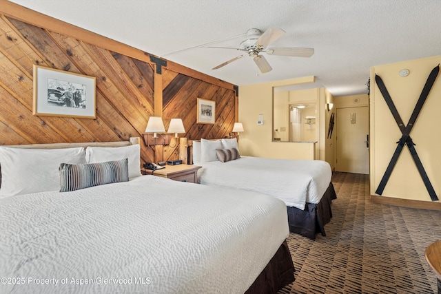 300 Carriage Way Unit 506, Snowmass Village, CO 81615 - bedroom featuring wooden walls, dark carpet, and ceiling fan