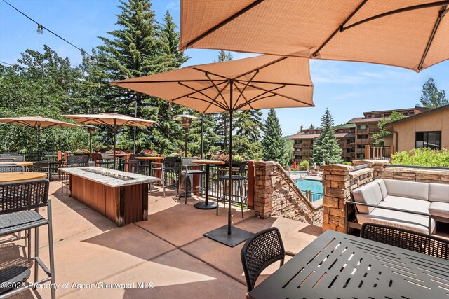 300 Carriage Way Unit 506, Snowmass Village, CO 81615 - view of patio / terrace featuring outdoor dining area, a community pool, and an outdoor living space with a fire pit