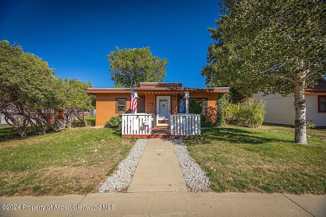 view of front of house with a front yard and a porch