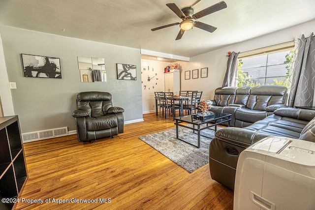 living room featuring ceiling fan and hardwood / wood-style flooring