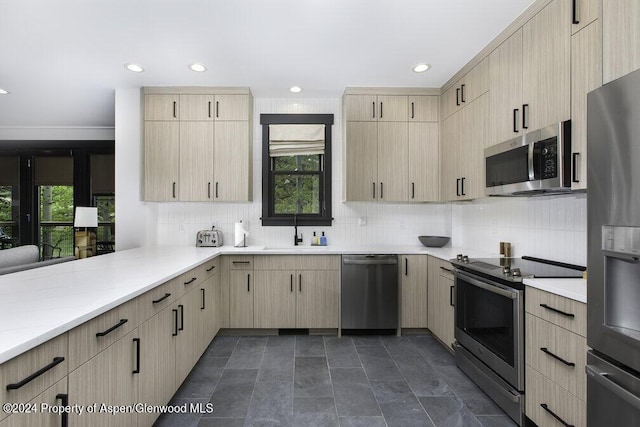 kitchen with sink, light brown cabinetry, tasteful backsplash, kitchen peninsula, and stainless steel appliances