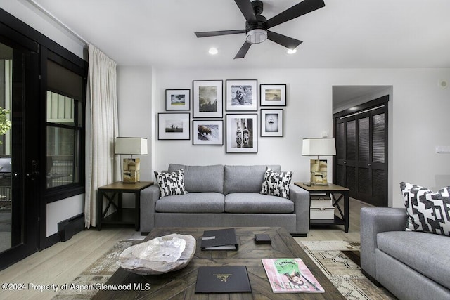 living room featuring ceiling fan and light hardwood / wood-style flooring