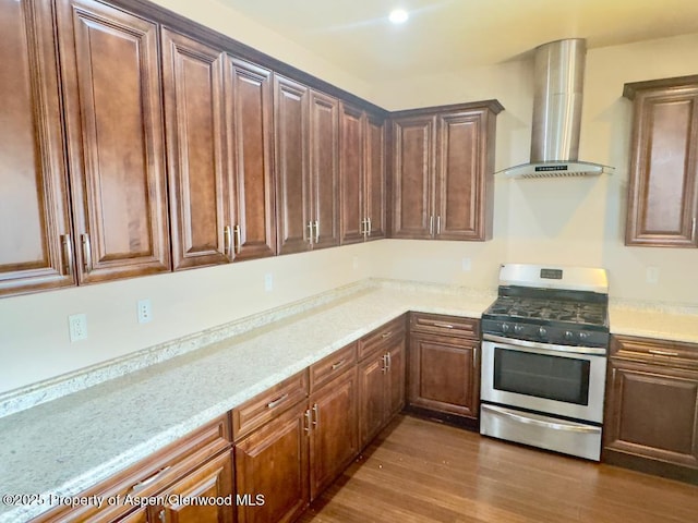1279 E 17th St, Rifle, CO 81650 - kitchen featuring stainless steel range with gas cooktop, wall chimney range hood, dark wood-type flooring, and light stone countertops