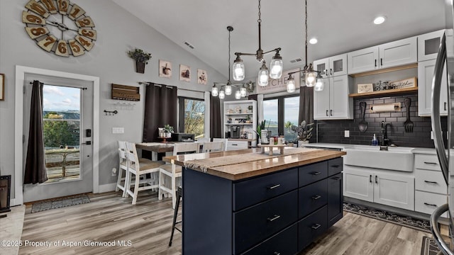450 E 10th St, Rifle, CO 81650 - kitchen with butcher block countertops, lofted ceiling, white cabinetry, a sink, and open shelves