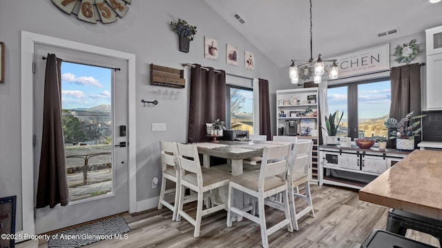 450 E 10th St, Rifle, CO 81650 - dining room with plenty of natural light, visible vents, lofted ceiling, and an inviting chandelier