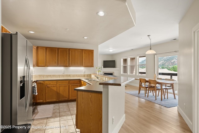 2701 Midland Ave Unit 725, Glenwood Springs, CO 81601 - kitchen featuring stainless steel refrigerator with ice dispenser, a peninsula, brown cabinetry, pendant lighting, and recessed lighting