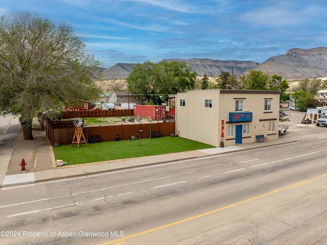 exterior space featuring a mountain view and a front yard