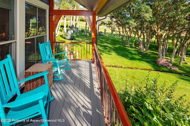 wooden terrace featuring a yard