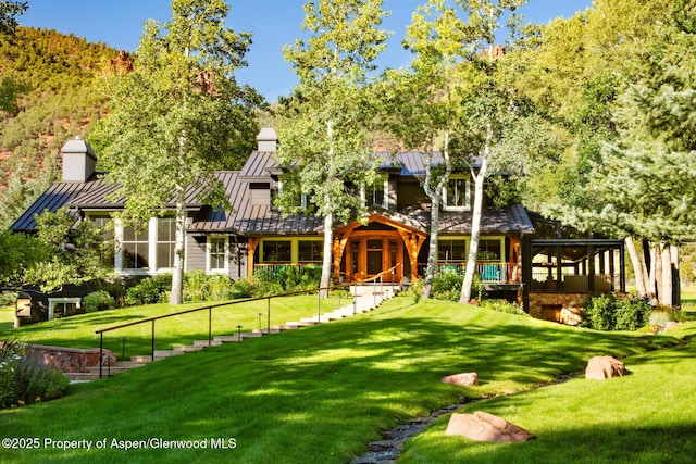 rear view of house with a yard and a sunroom