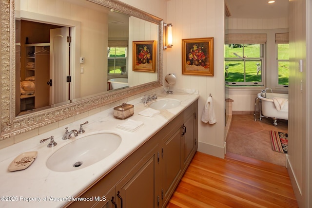 bathroom featuring vanity, a bath, and hardwood / wood-style floors