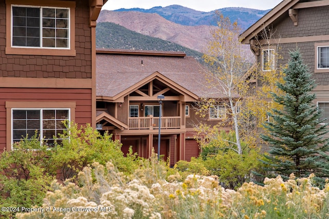 back of house featuring a mountain view and a balcony