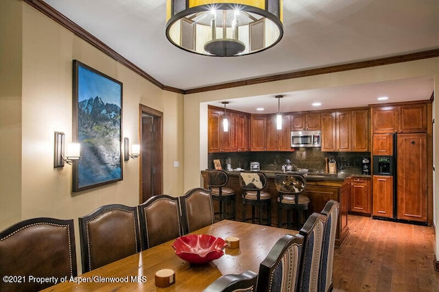 dining space with dark hardwood / wood-style flooring and ornamental molding