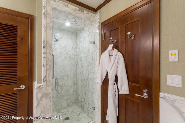 bathroom with an enclosed shower and crown molding