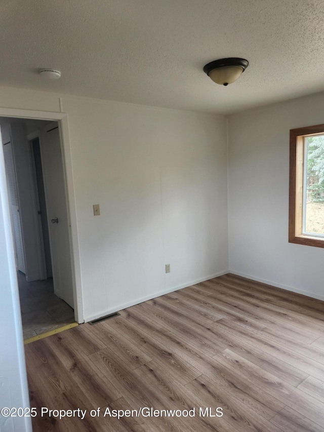 12 W Tamarack Cir, Battlement Mesa, CO 81635 - spare room featuring a textured ceiling, wood finished floors, and baseboards