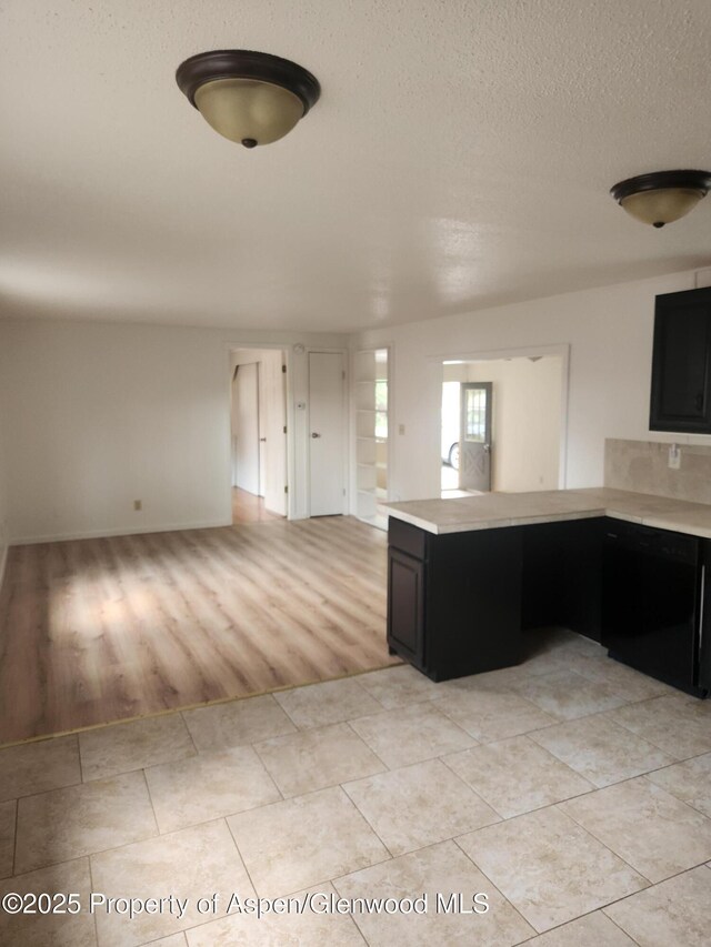 12 W Tamarack Cir, Battlement Mesa, CO 81635 - kitchen with dishwasher, light countertops, dark cabinets, and a textured ceiling