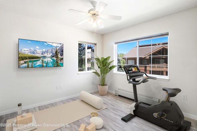 workout room featuring a baseboard radiator, wood finished floors, a ceiling fan, and baseboards