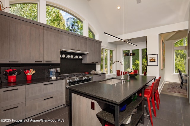 205 N 6th St, Aspen, CO 81611 - kitchen featuring high end range, dark countertops, a breakfast bar area, modern cabinets, and high vaulted ceiling