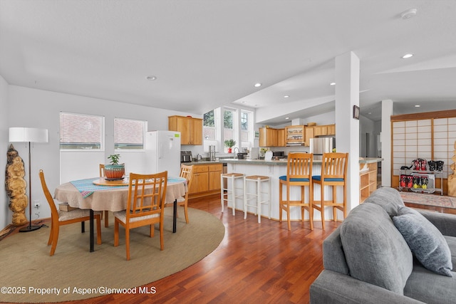 dining room with vaulted ceiling, recessed lighting, and wood finished floors