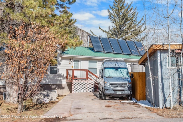 view of front of home featuring metal roof and solar panels