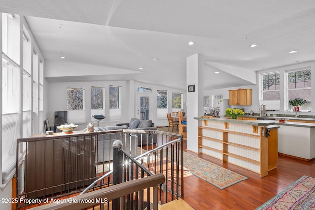 kitchen with recessed lighting, open floor plan, wood finished floors, and vaulted ceiling