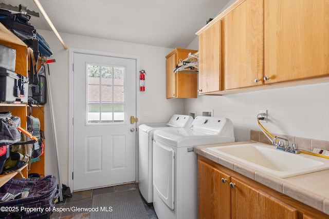 laundry area with washer and clothes dryer, cabinet space, and a sink