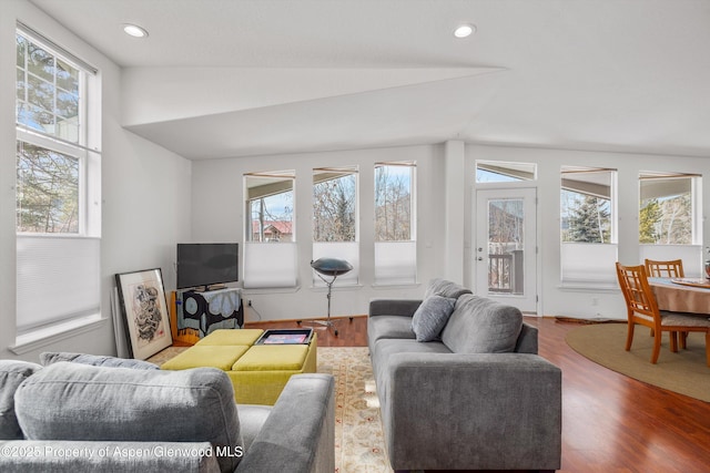 living area with recessed lighting, lofted ceiling, and wood finished floors