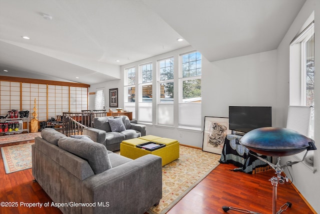 living room with vaulted ceiling, recessed lighting, wood finished floors, and a wealth of natural light