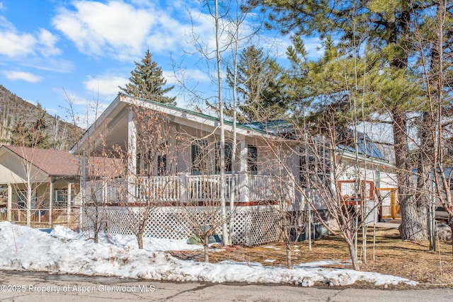 view of snowy exterior featuring covered porch