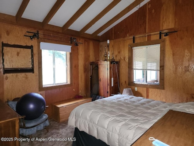 bedroom with multiple windows, lofted ceiling with beams, and wood walls