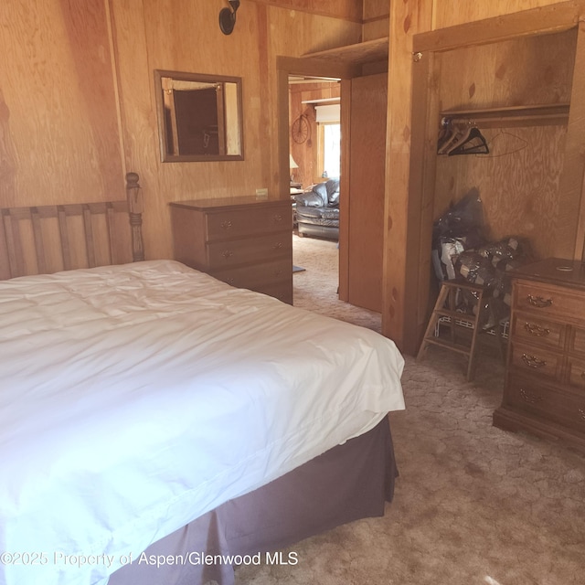 bedroom featuring wooden walls, carpet floors, and a closet