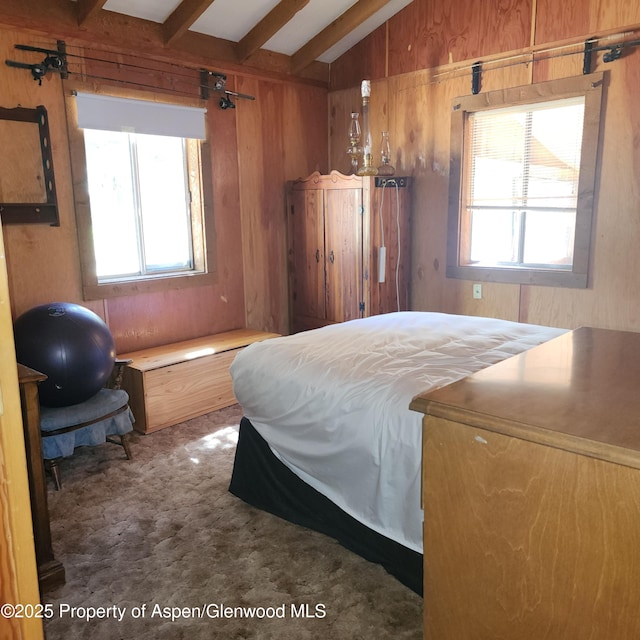 bedroom featuring wood walls, lofted ceiling with beams, and multiple windows